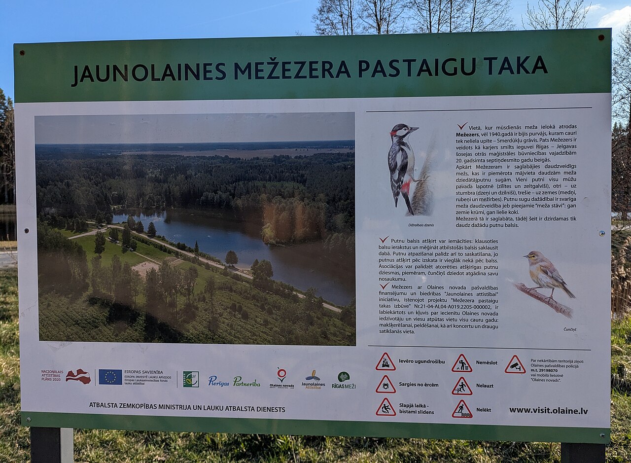 Mežezera pastaigu takas informācijas stends ar ezera fotoattēlu